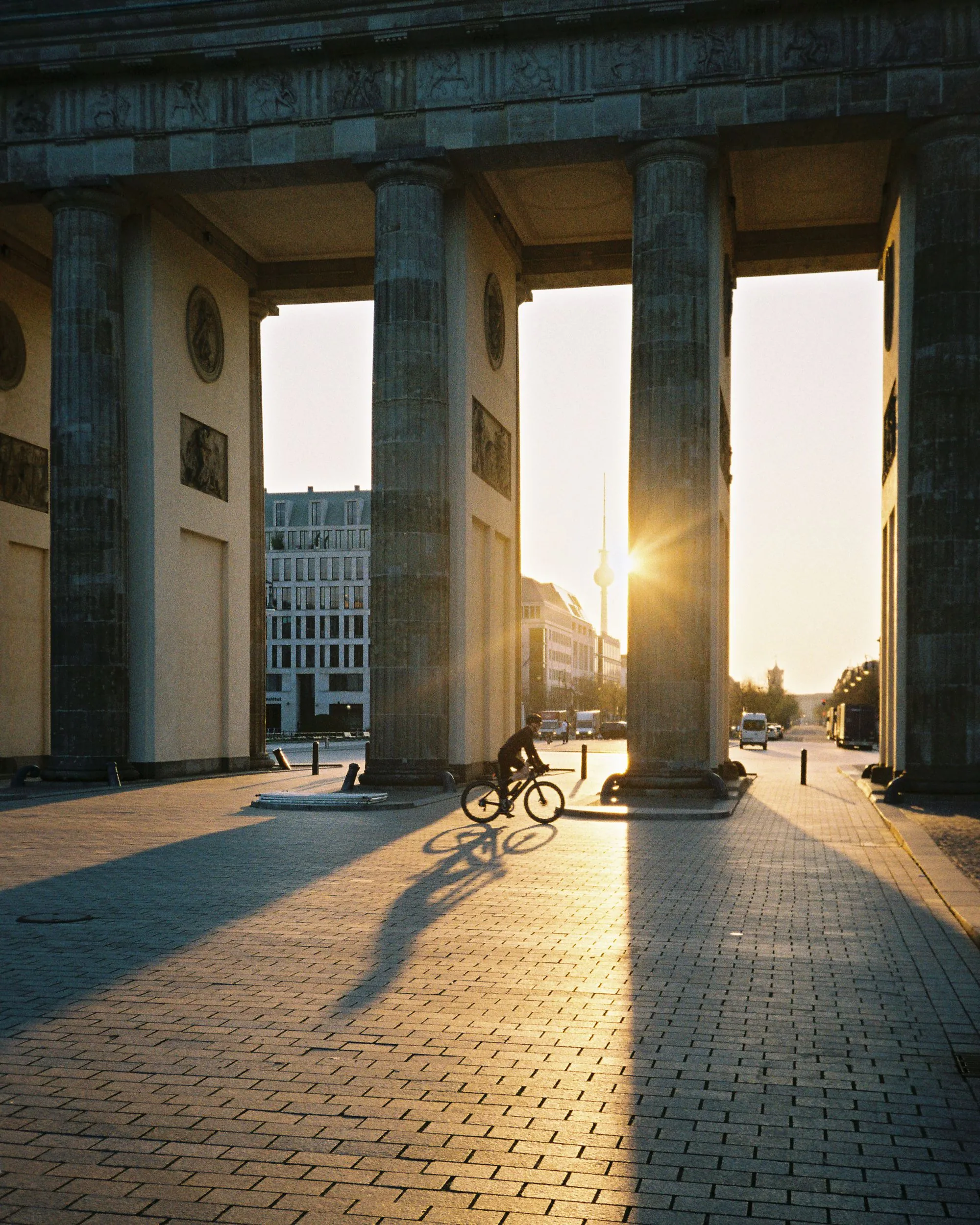 A cyclist passing the Brandenburg Gate at sunset, Berlin
